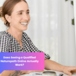 Woman smiling during an online naturopathic consultation via laptop in a calm home setting.
