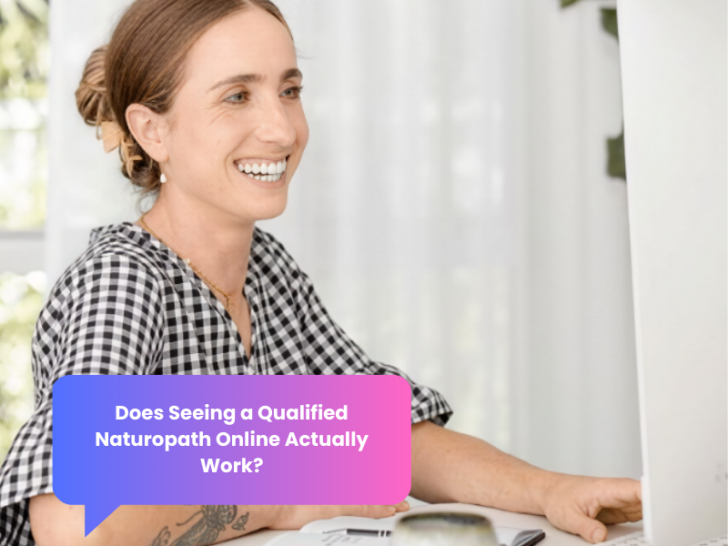 Woman smiling during an online naturopathic consultation via laptop in a calm home setting.